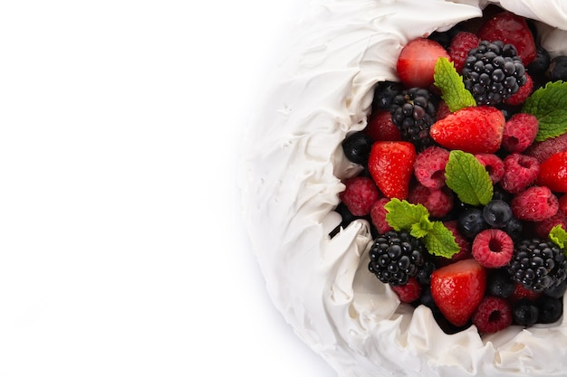 Delicioso pastel de Pavlova con merengue y bayas frescas aisladas sobre fondo blanco.