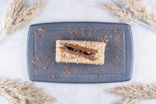 Delicioso pastel en un plato oscuro con espigas de trigo. Foto de alta calidad