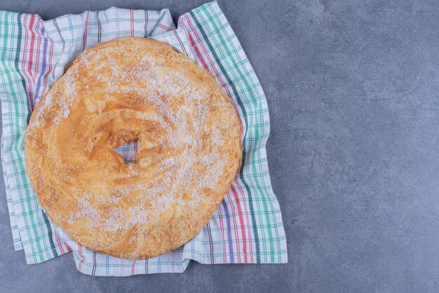 Un delicioso pastel redondo con azúcar en polvo sobre un mantel