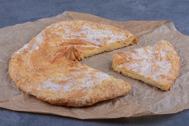 Un delicioso pastel redondo con azúcar en polvo sobre un mantel