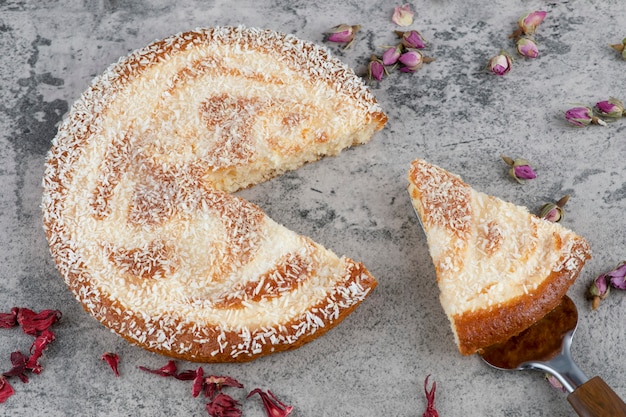 Delicioso pastel redondo picado colocado sobre una mesa de mármol.