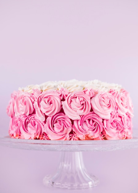 Delicioso pastel rosa con rosas en el stand