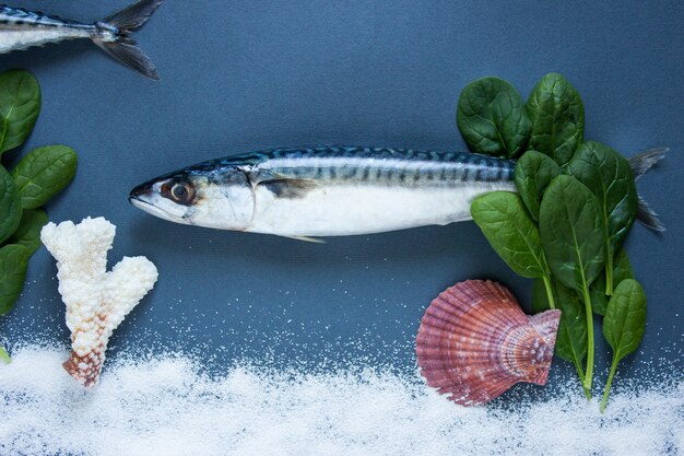 Delicioso pescado fresco sobre fondo azul. Pescado con hierbas aromáticas, cebolla, peces en el agua concepto de natación