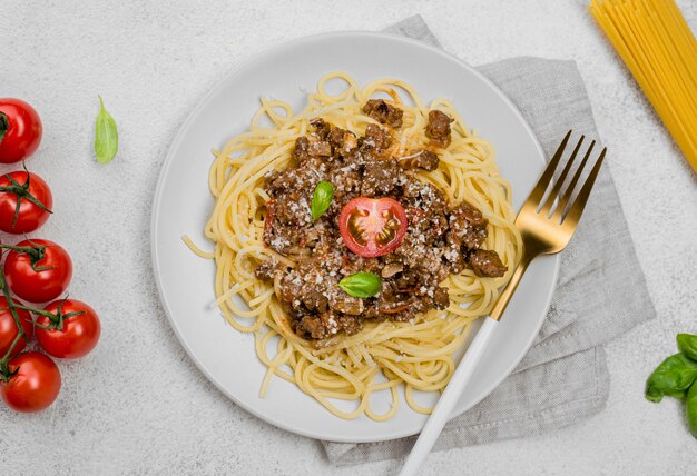 Delicioso plato con spaghetii a la boloñesa en el escritorio