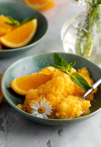 Foto gratuita delicioso postre de granizado de alto ángulo con bodegón de naranja