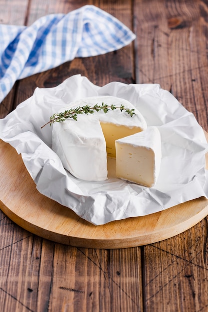 Delicioso queso en lonchas en la tabla de cortar alta vista