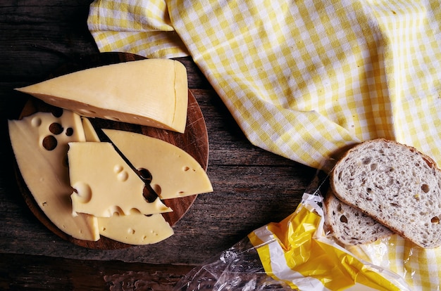 Delicioso queso sobre tabla de madera y pan