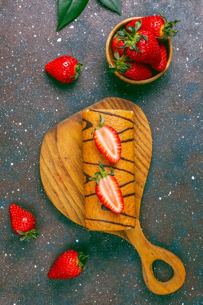 Delicioso rollo de tarta de fresas con fresas frescas