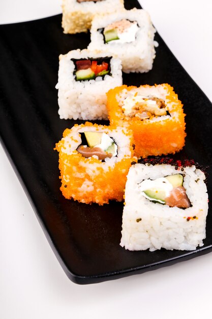 Delicioso sushi en plato negro