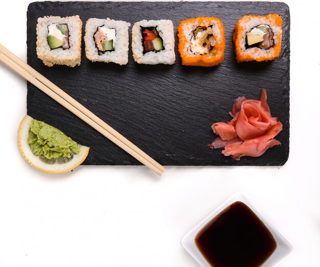 Delicioso sushi en plato negro