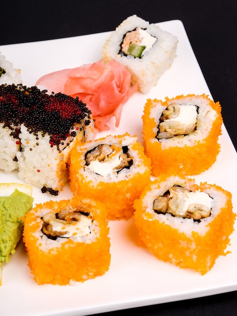 Delicioso sushi en plato negro