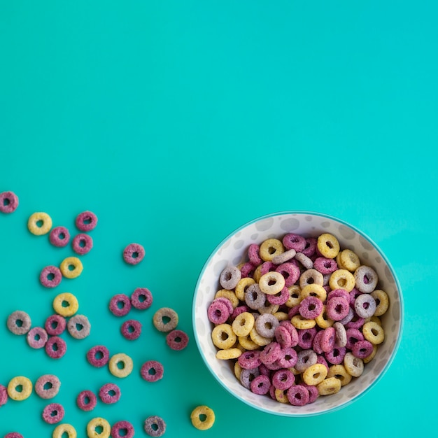 Delicioso tazón de cereales sobre fondo azul.