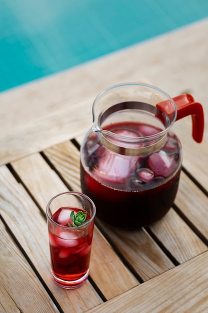 Foto gratuita delicioso té helado de alto ángulo en la mesa en la piscina