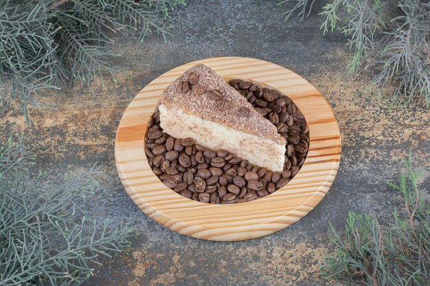 Un delicioso trozo de tarta con granos de café sobre tabla de madera. Foto de alta calidad