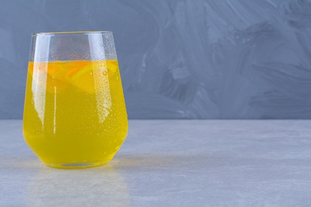 Delicioso un vaso de jugo de naranja en la mesa de mármol.