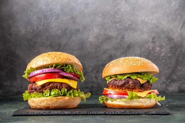 Deliciosos bocadillos caseros en tablero negro sobre superficie borrosa gris