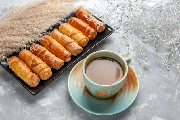 Deliciosos brazaletes con café con leche en un escritorio ligero, pastel de pastelería dulce de azúcar