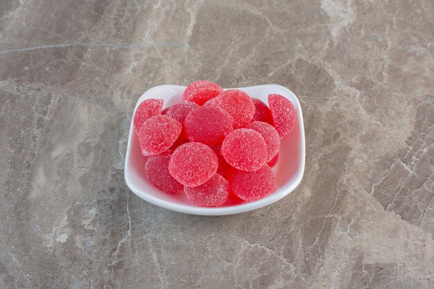 Deliciosos caramelos de gelatina rosa en un tazón blanco.