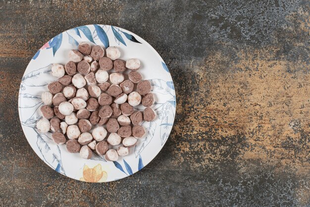 Deliciosos caramelos marrones en plato colorido.