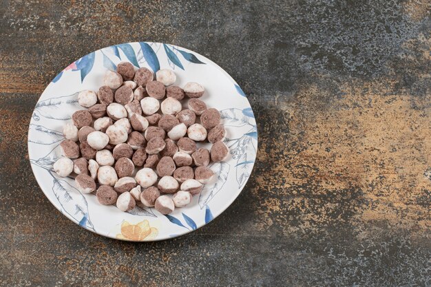 Deliciosos caramelos marrones en plato colorido.