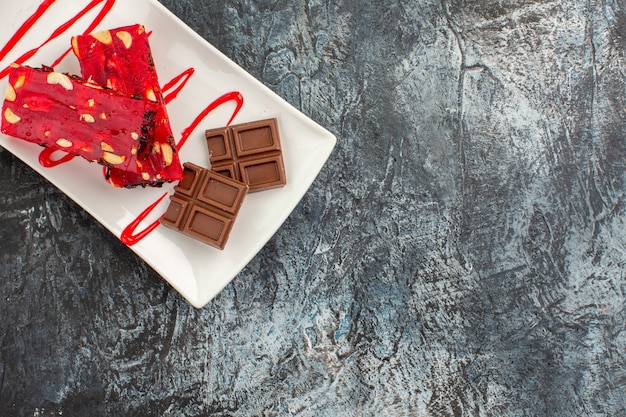 Deliciosos chocolates en la placa blanca en la esquina izquierda del suelo gris