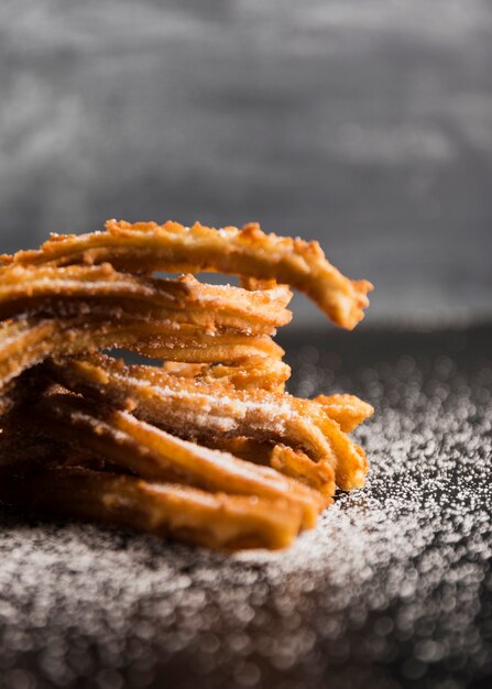 Deliciosos churros de primer plano sobre una mesa con azúcar borrosa