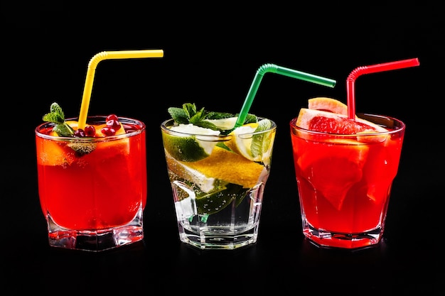 Foto gratuita deliciosos cócteles de mojito, ron y cola, naranja sanguina y vodka con fruta