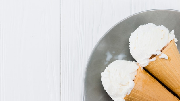 Foto gratuita deliciosos conos de helado de vainilla en placa