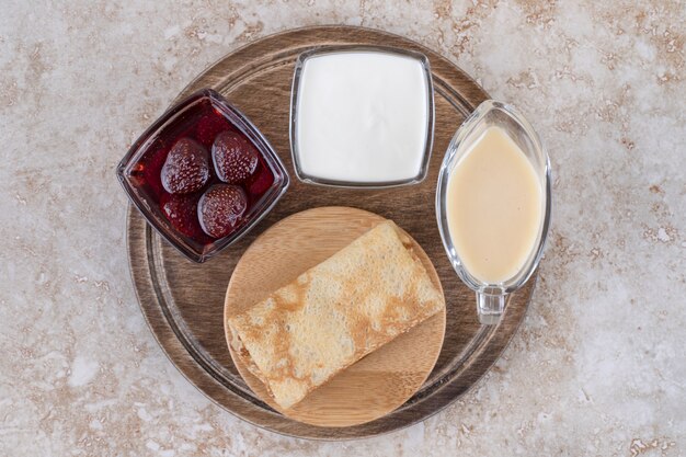 Deliciosos crepes con crema agria y mermelada de fresa