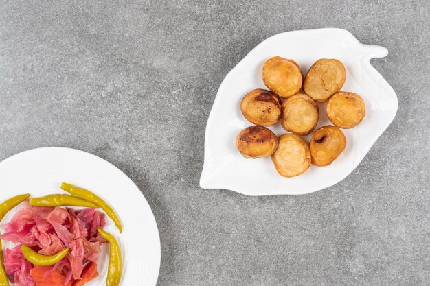 Deliciosos dumplings fritos en un plato blanco con encurtidos