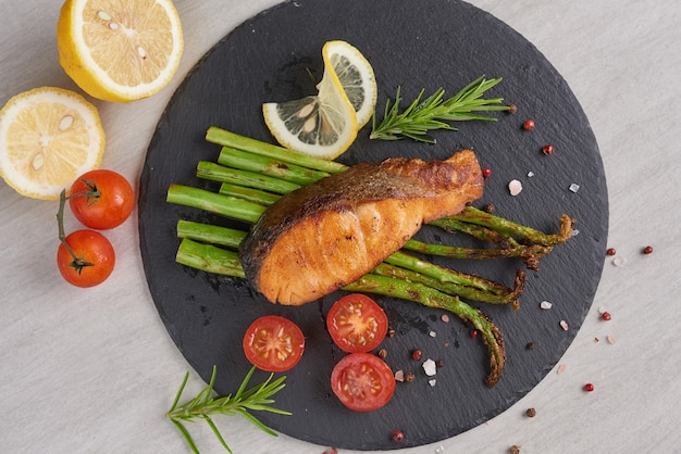 Deliciosos espárragos verdes y salmón ahumado en rodajas en un plato rústico