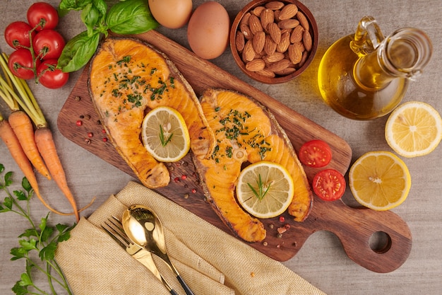 Deliciosos filetes de salmón cocidos. Filete de salmón a la plancha y ensalada de tomate vegetal con lechuga verde fresca. Concepto de nutrición equilibrada para una dieta mediterránea flexitariana de alimentación limpia.