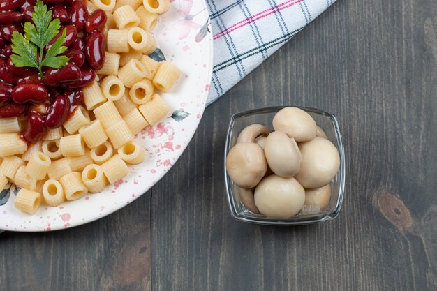 Deliciosos macarrones con frijoles y pimienta en una mesa de madera