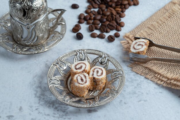 Deliciosos panecillos dulces, granos de café y café turco sobre fondo de piedra. Foto de alta calidad