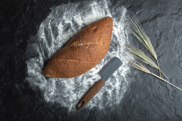 Deliciosos panes frescos sobre fondo blanco con cuchillo