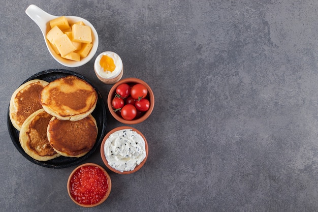 Deliciosos panqueques con mantequilla y tomates cherry rojos frescos.