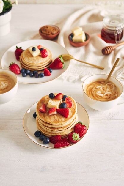 Deliciosos panqueques veganos con frutas en una placa blanca.