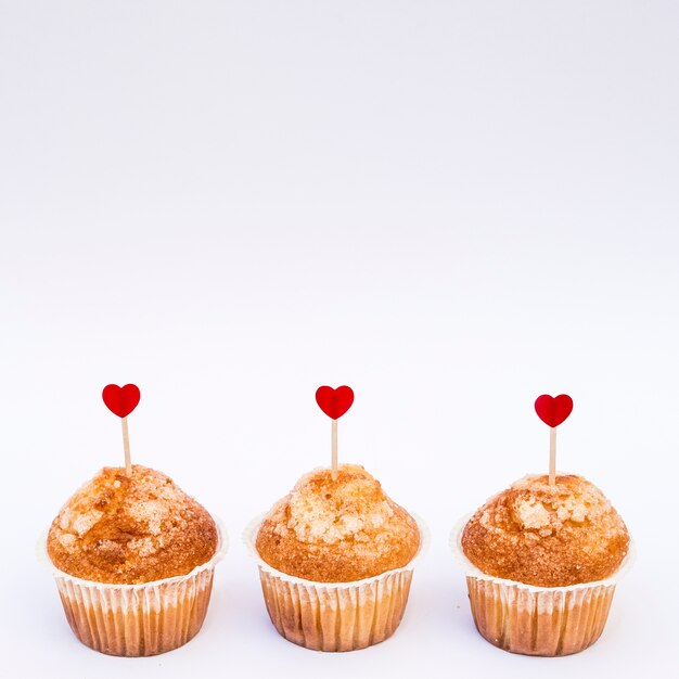 Deliciosos pasteles con adornos de corazones en varitas.