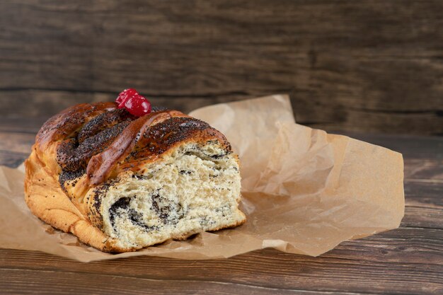 Deliciosos pasteles dulces con chocolate en hoja para cocinar sobre superficie de madera.