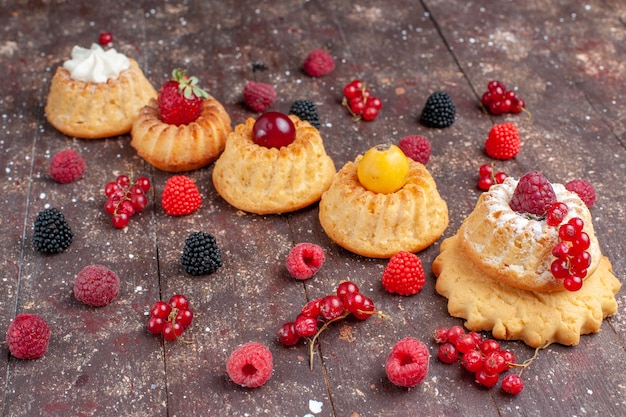 deliciosos pasteles y galletas con diferentes bayas a lo largo de marrón rústico, galleta de bizcocho de bizcocho