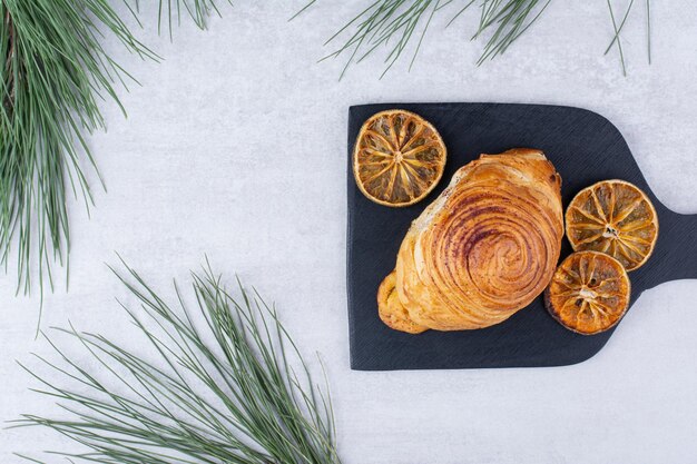 Deliciosos pasteles con rodajas de naranja secas en tablero negro. Foto de alta calidad