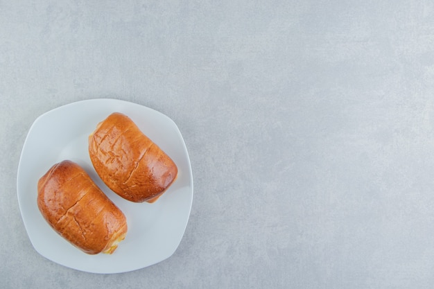 Deliciosos pasteles con salchichas en plato blanco.