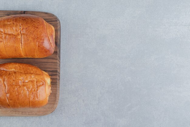 Deliciosos pasteles con salchichas sobre tabla de madera.