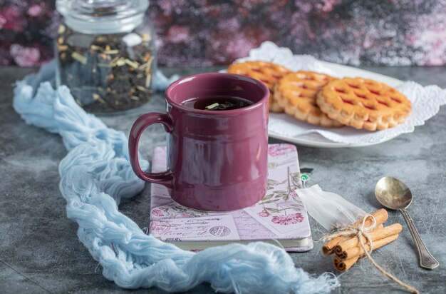 Deliciosos pasteles con taza de té y canela en rama.