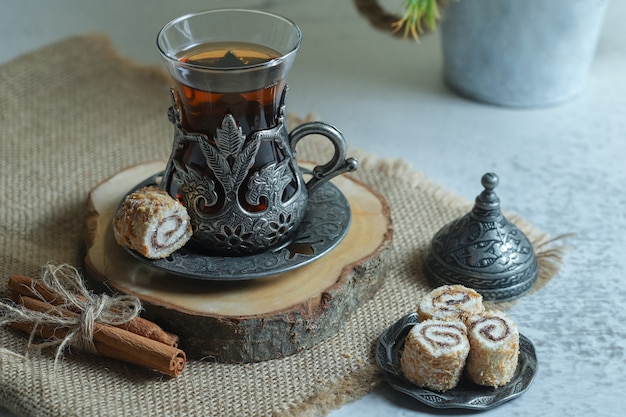 Deliciosos postres de lokum y vaso de té en la superficie de piedra.