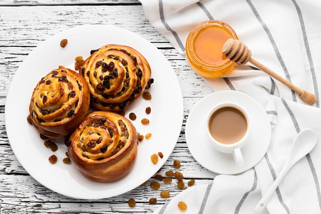 Deliciosos rollos de pasas de canela sobre mesa de madera