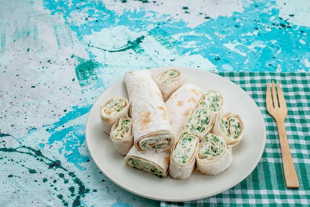 deliciosos rollos de vegetales enteros y en rodajas en azul brillante, rollo de comida vegetal