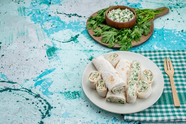 Deliciosos rollos de verduras enteros y en rodajas con verduras y ensalada en azul brillante, rollo de comida, bocadillo de verduras