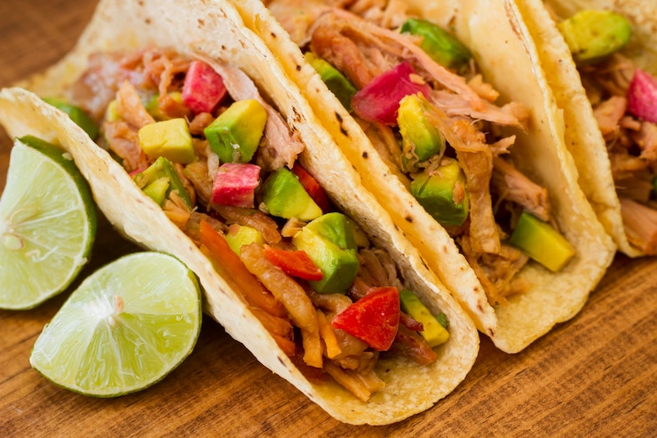 Foto gratuito deliciosos tacos en ángulo alto de tablero de madera
