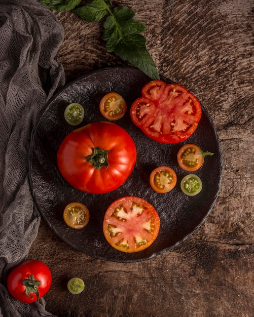 Deliciosos tomates frescos en la placa vista anterior